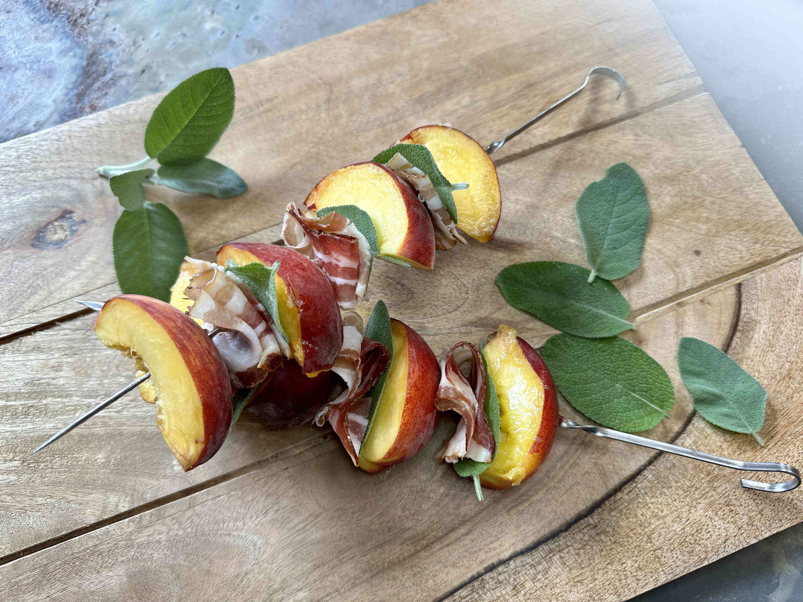 Grilled skewers with peaches, bacon and sage